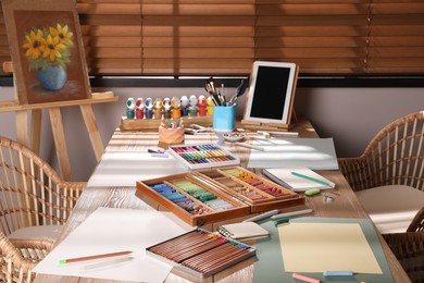Photo of Artist's workplace with soft pastels, tablet and drawing pencils on table