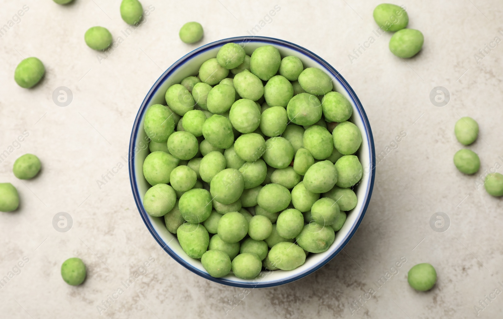 Photo of Tasty wasabi coated peanuts on table, flat lay