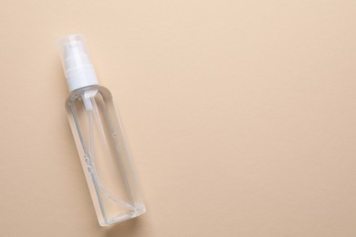 Micellar water on beige background, top view. Space for text