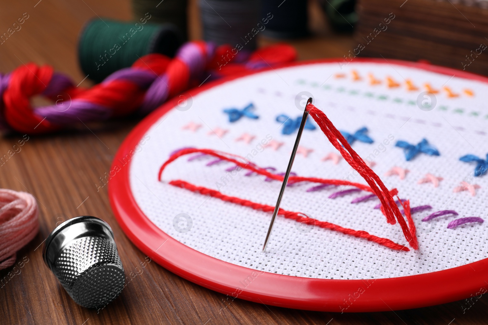 Photo of Set of embroidery equipment on wooden table, closeup