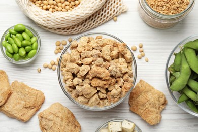 Different organic soy products on white wooden table, flat lay