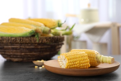 Photo of Plate with tasty sweet corn cobs on table