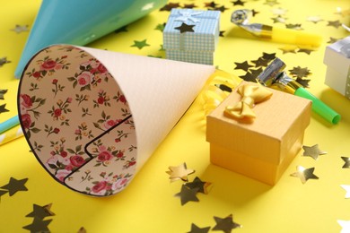 Party hats and other bright decor elements on yellow background