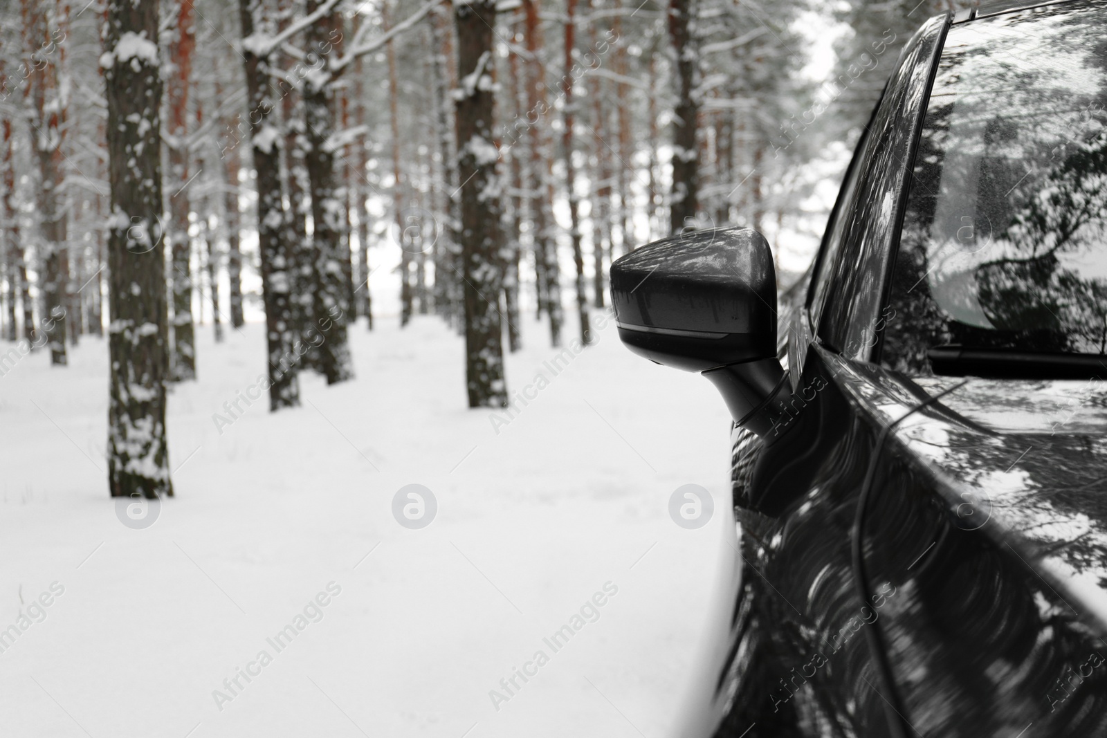 Photo of Snowy country road with car on winter day, closeup with space for text