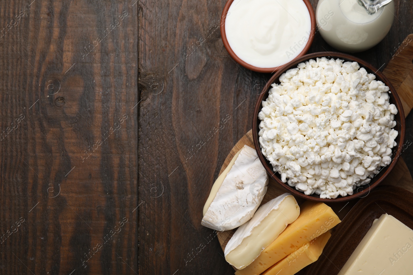 Photo of Different fresh dairy products on wooden table, flat lay. Space for text