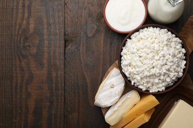 Different fresh dairy products on wooden table, flat lay. Space for text