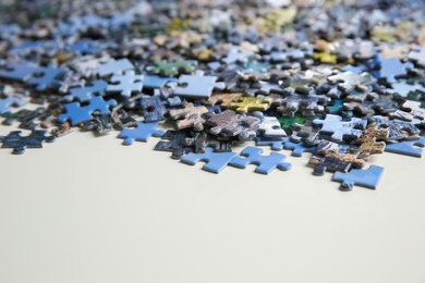 Photo of Puzzle pieces on white table, closeup view