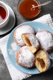 Photo of Delicious sweet buns with jam and cup of tea on table, flat lay