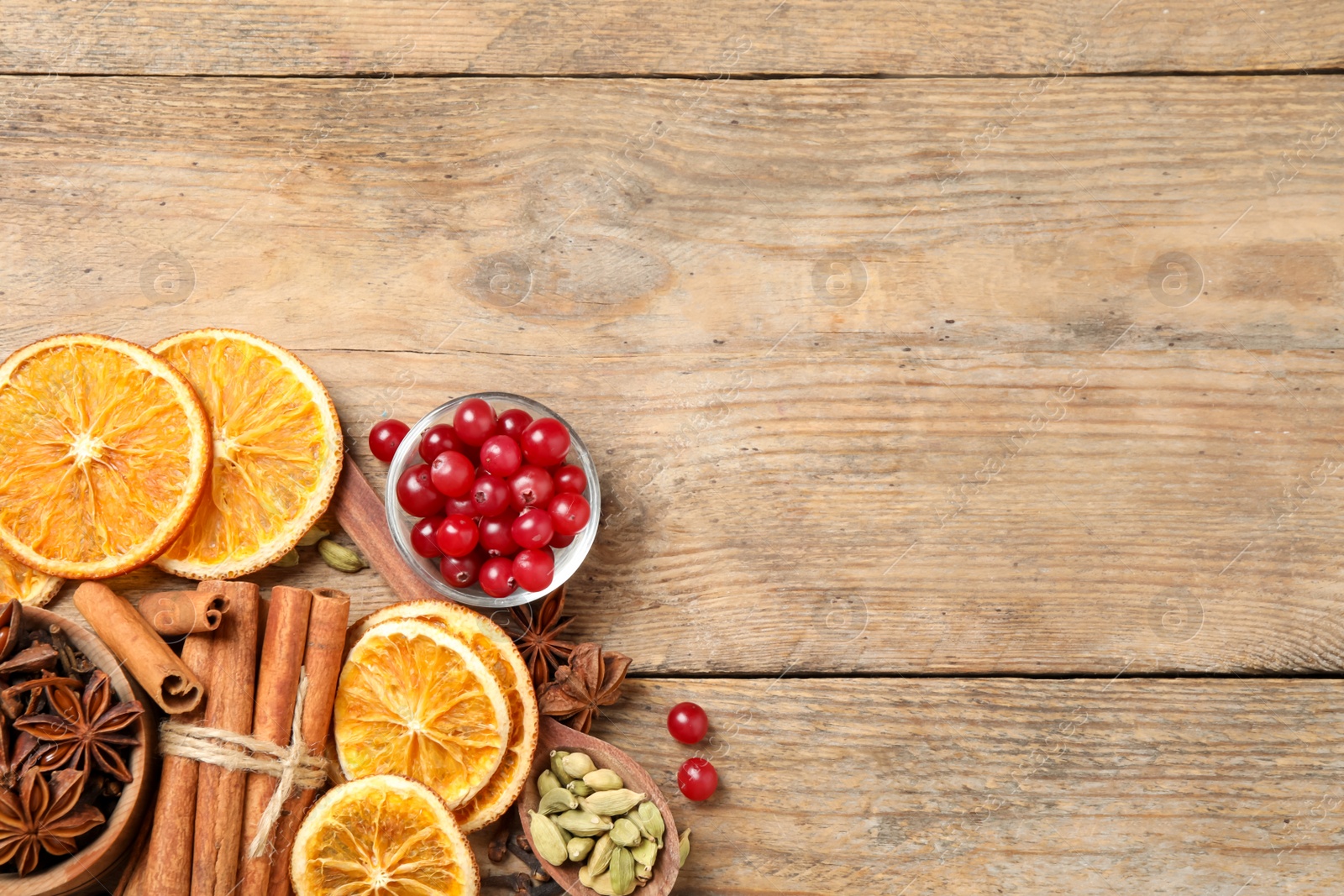 Photo of Flat lay composition with mulled wine ingredients on wooden table, flat lay. Space for text