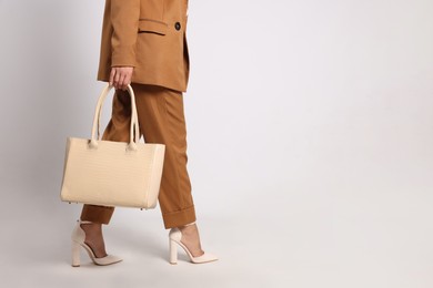 Young woman with stylish bag on white background, closeup