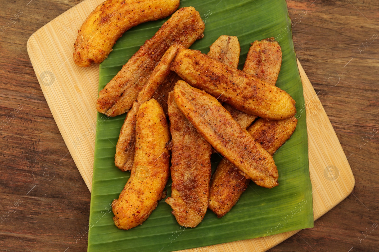 Photo of Delicious fried bananas on wooden table, top view