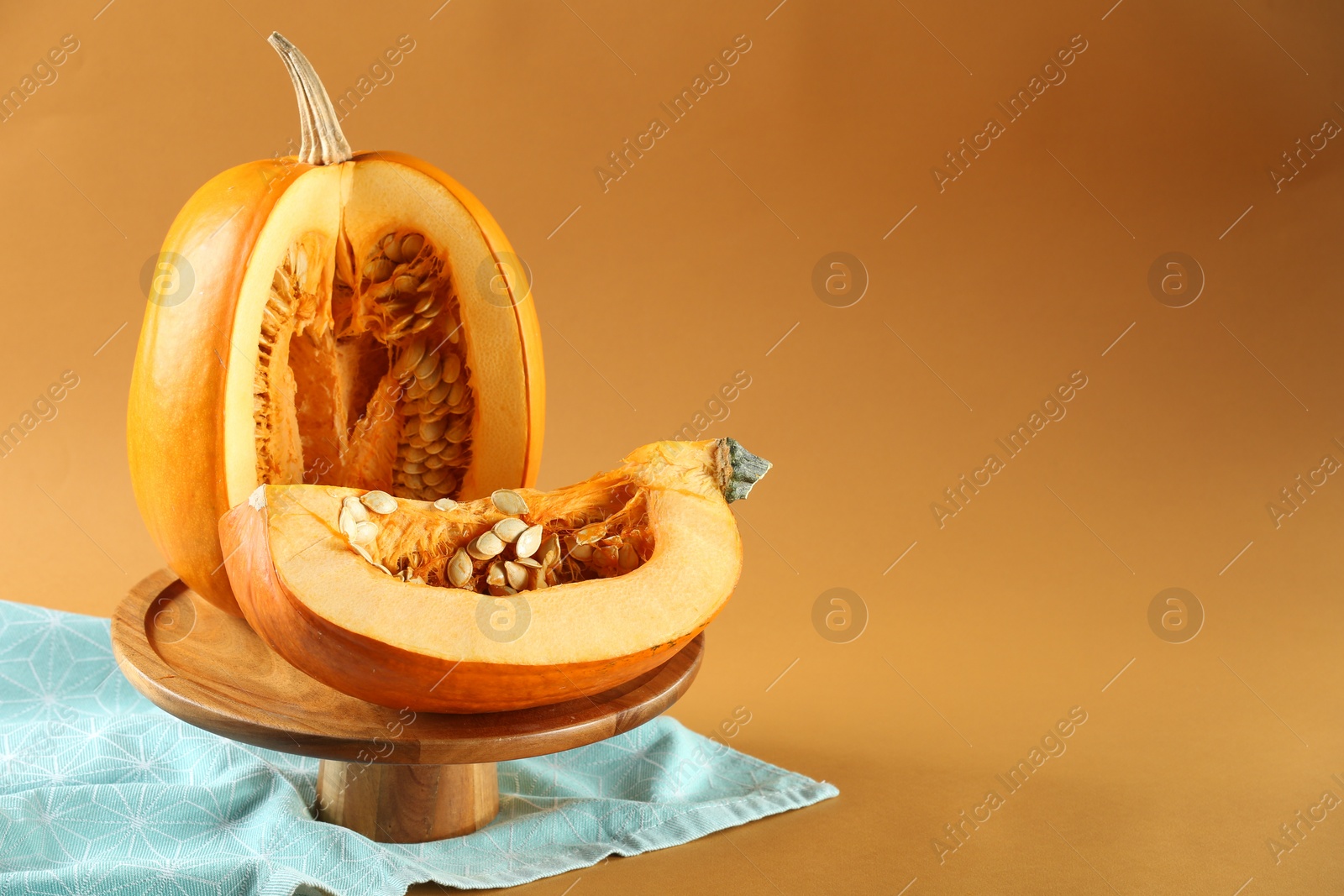 Photo of Cut fresh ripe pumpkin on orange background, space for text