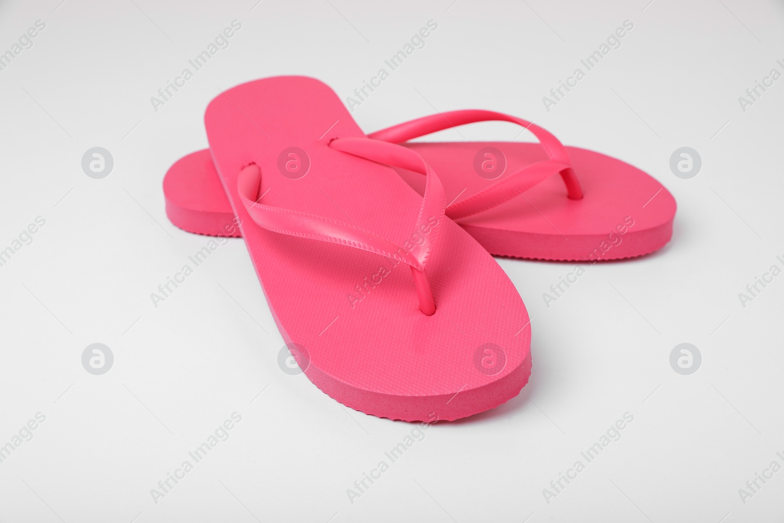 Photo of Stylish pink flip flops on white background