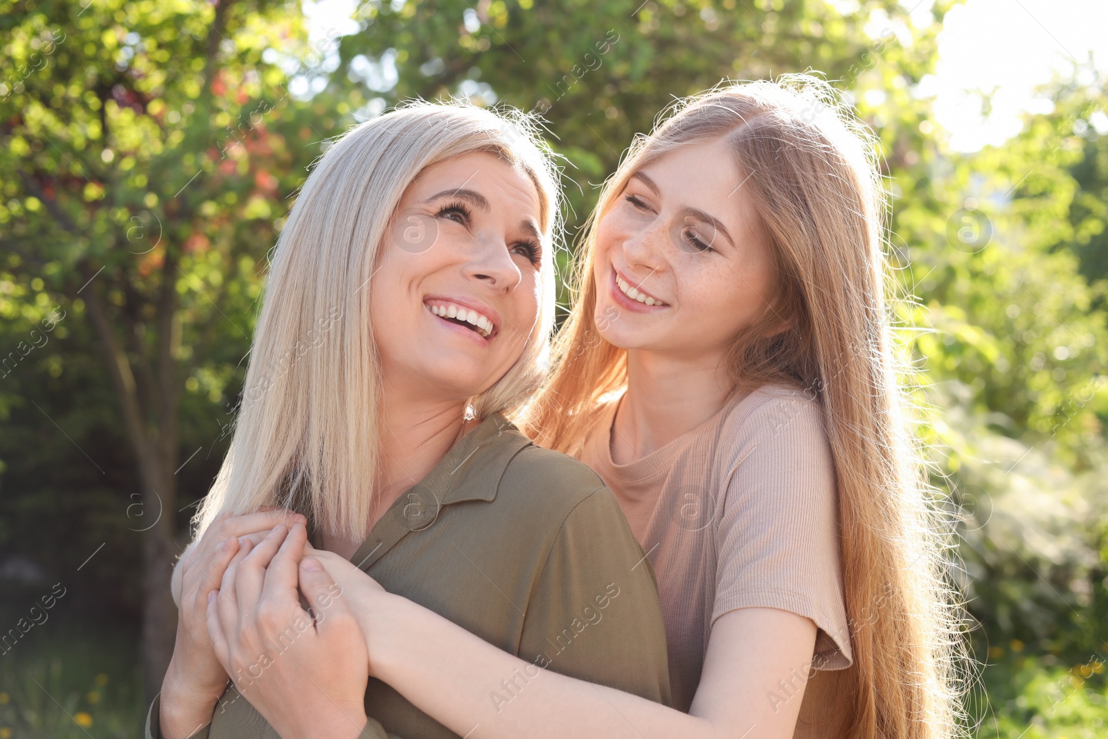 Photo of Happy mother with her daughter spending time together in park on sunny day