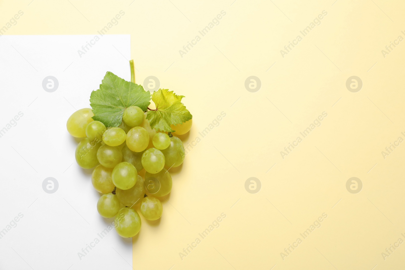 Photo of Fresh ripe juicy grapes on color background, top view. Space for text