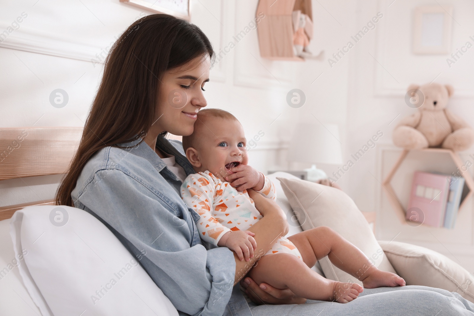 Photo of Mother with her cute baby on bed at home