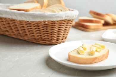 Slice of tasty fresh bread with butter on light marble table