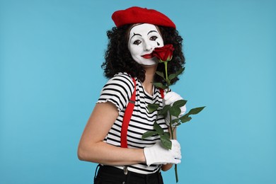 Funny mine with red rose posing on light blue background