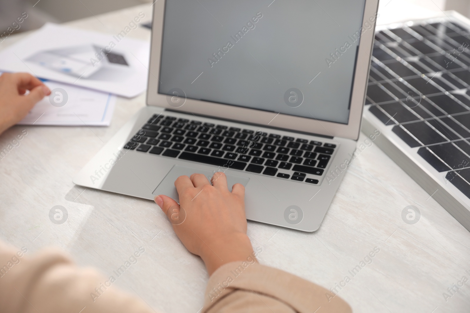 Photo of Woman working on project with solar panels at table in office, closeup