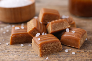 Photo of Delicious salted caramel on wooden table, closeup