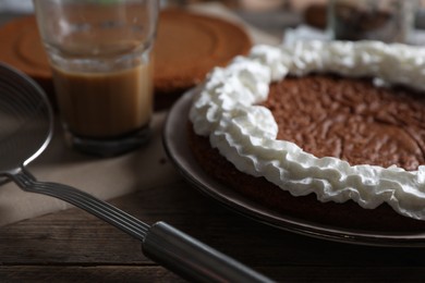 Photo of Delicious homemade sponge cake with cream on wooden table, closeup