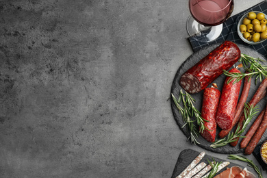 Different types of sausages served on grey table, flat lay. Space for text