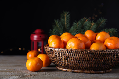 Photo of Ripe tangerines on wooden table against dark background. Christmas celebration