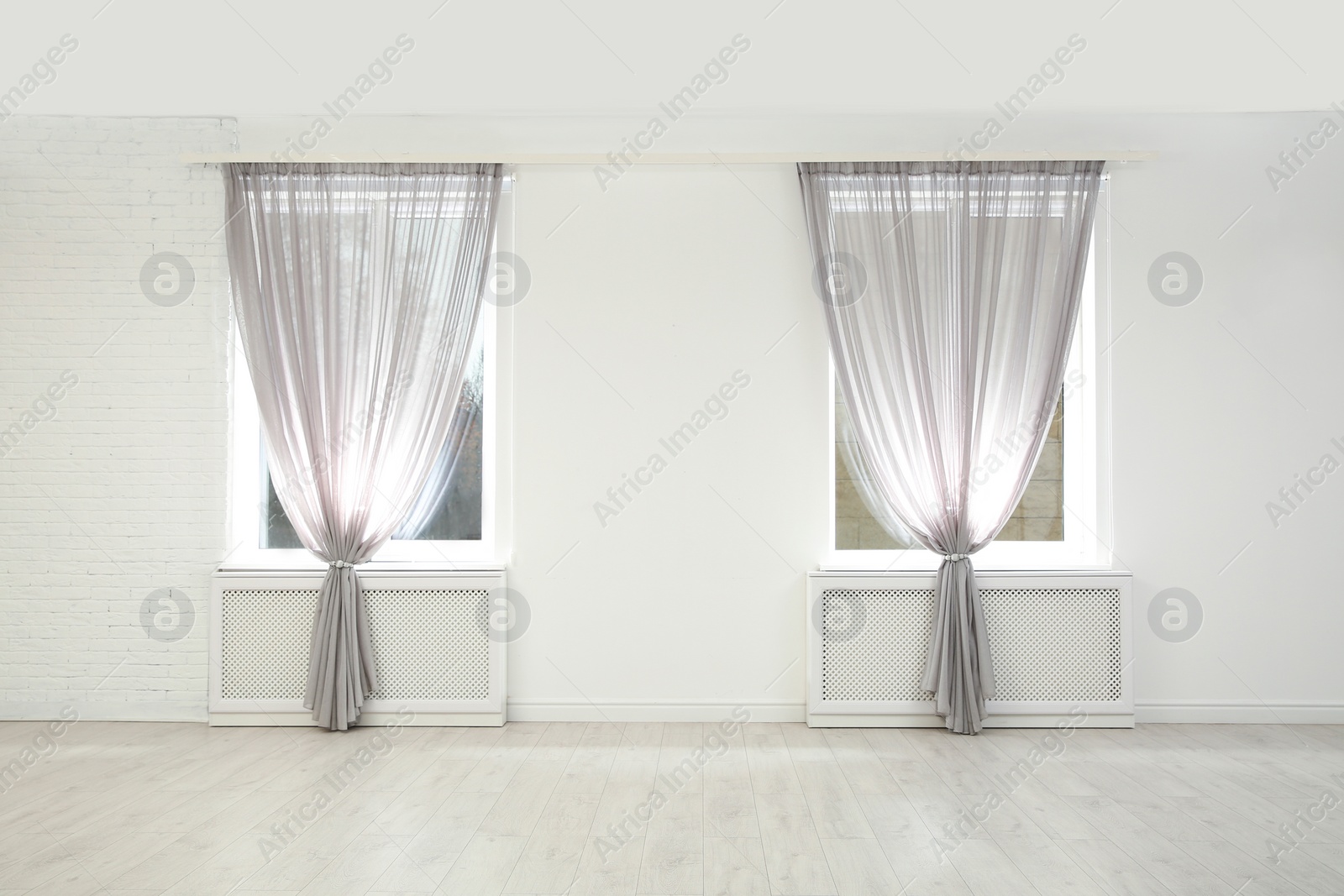 Photo of Modern windows with curtains in room. Home interior