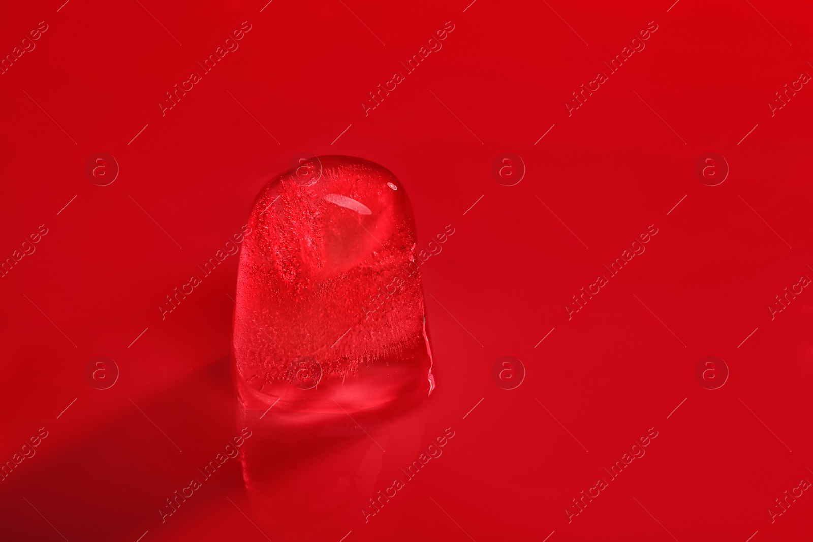 Photo of Ice cube on color background. Space for text