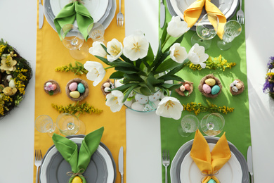 Photo of Festive Easter table setting with beautiful tulips and eggs, flat lay