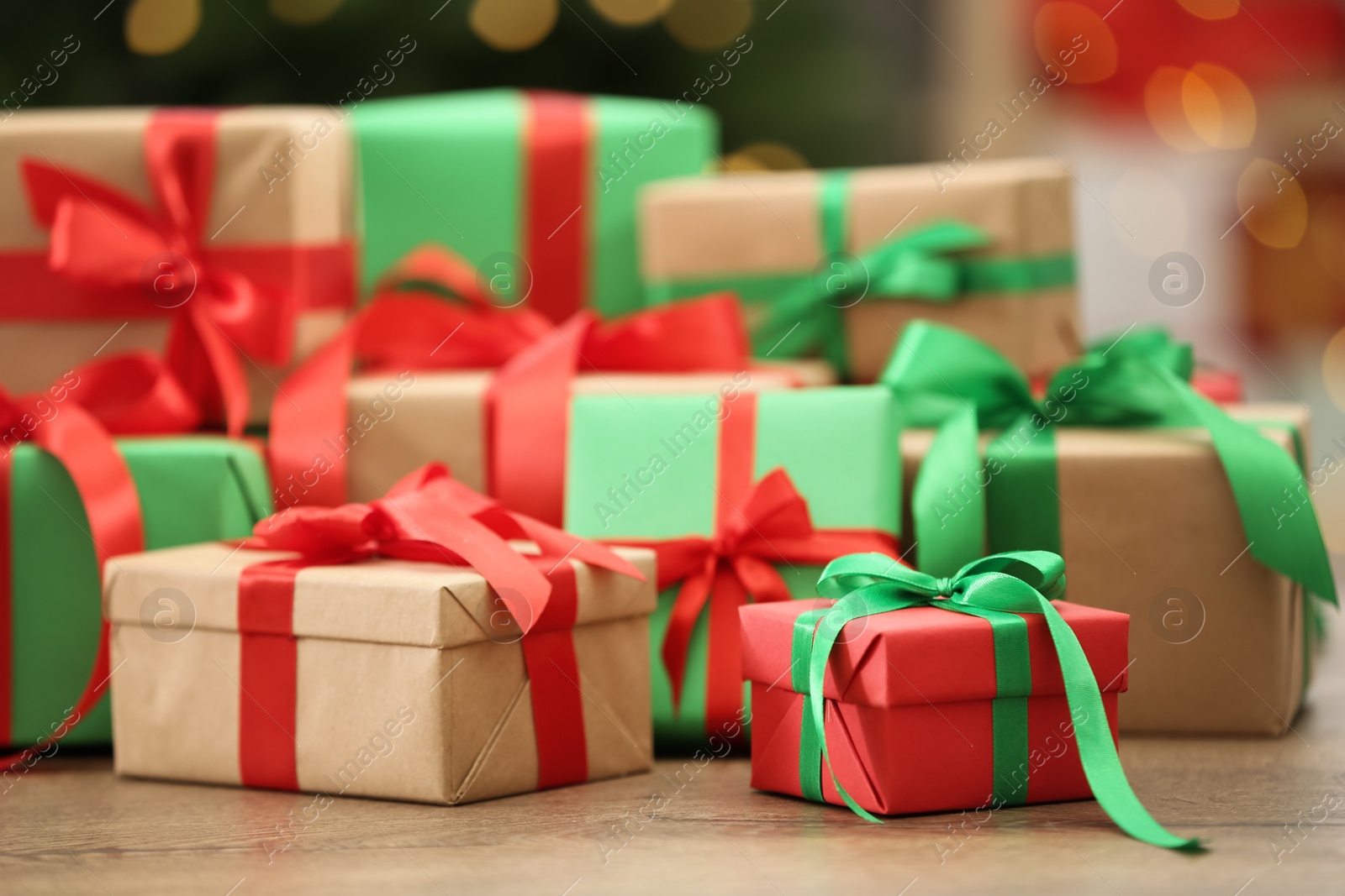 Photo of Many Christmas gifts on table against blurred background