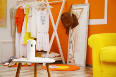 Photo of Automatic air freshener on table in room