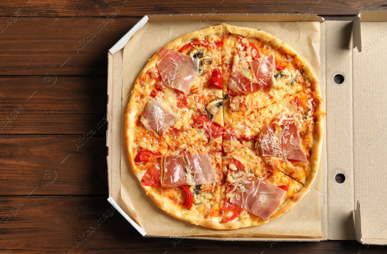 Photo of Carton box with delicious pizza on wooden background, top view