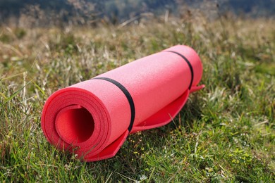 Photo of Rolled pink soft sleeping pad on grass