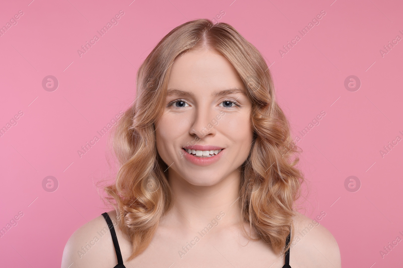 Photo of Portrait of beautiful woman with blonde hair on pink background