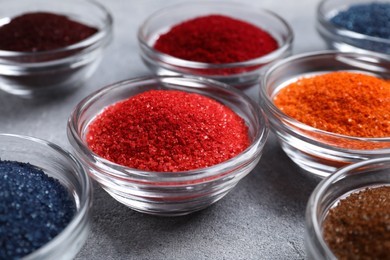 Photo of Different food coloring on light grey table, closeup