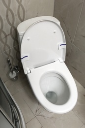 Photo of Modern white toilet bowl with seat in bathroom, above view