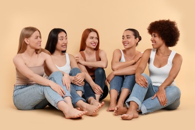 Photo of Group of beautiful young women sitting on beige background