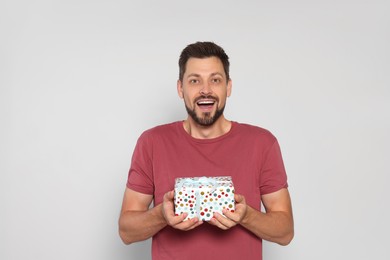 Photo of Happy man with gift box on white background