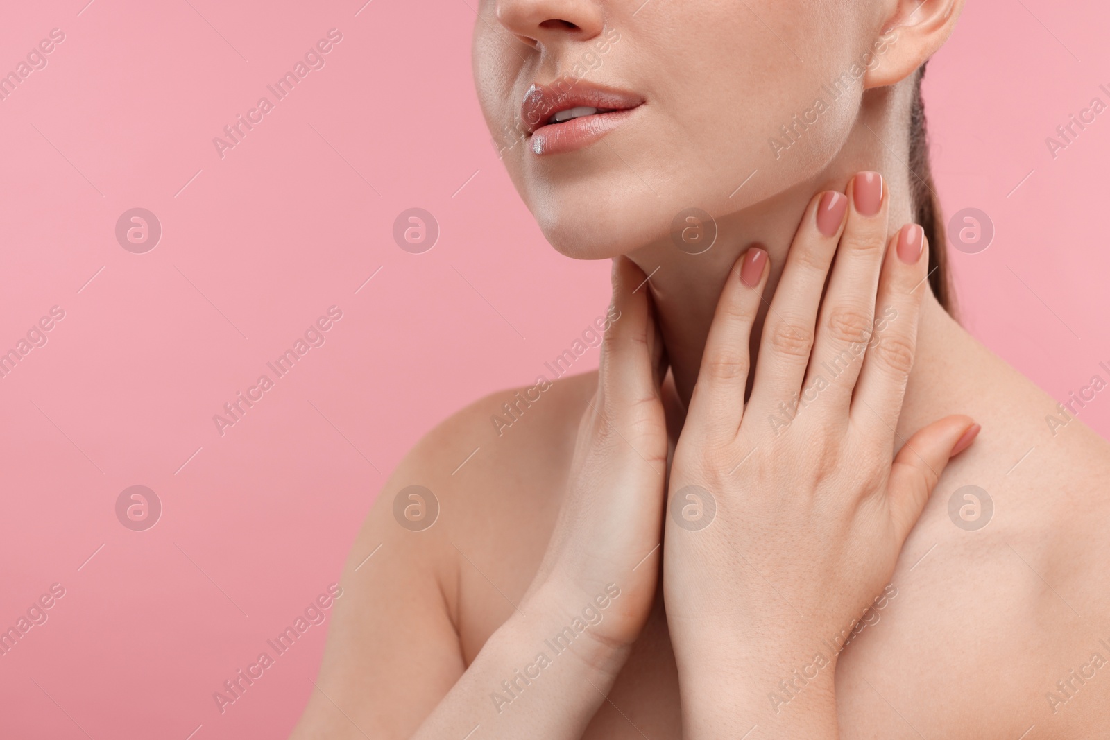 Photo of Woman touching her neck on pink background, closeup. Space for text