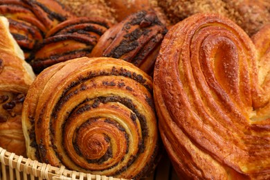 Photo of Wicker basket with different tasty freshly baked pastries, closeup