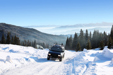 Photo of Modern car on snowy country road. Winter vacation