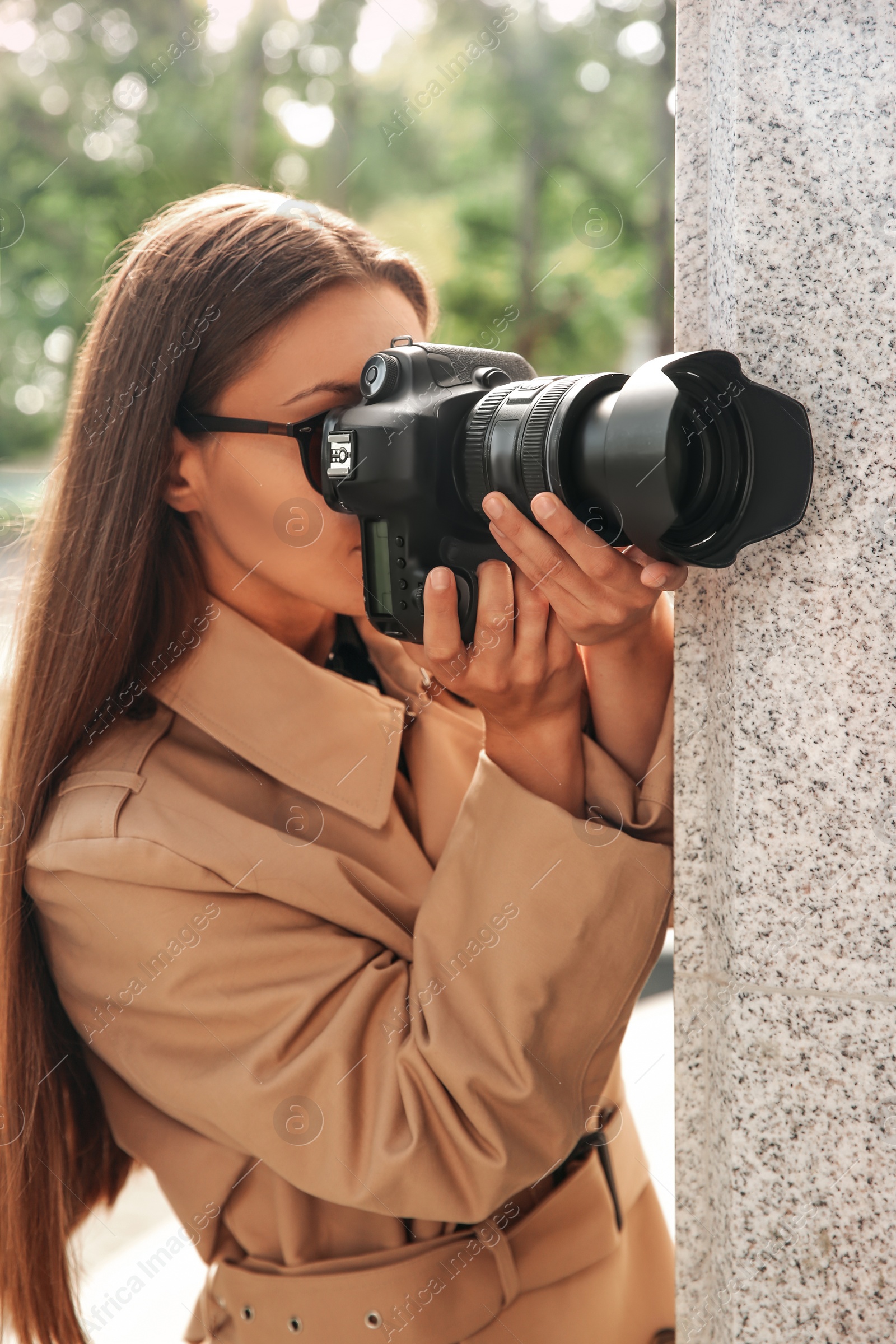 Photo of Private detective with camera spying near building on city street