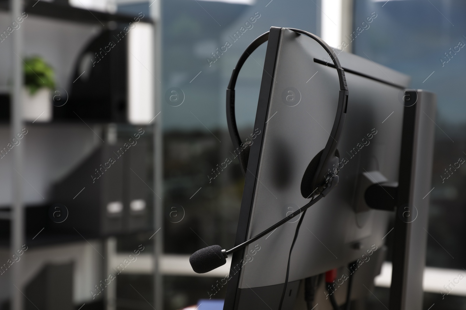 Photo of Modern computer with headset indoors. Hotline service