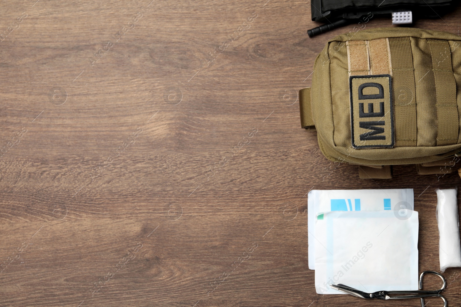 Photo of Military first aid kit on wooden table, flat lay. Space for text