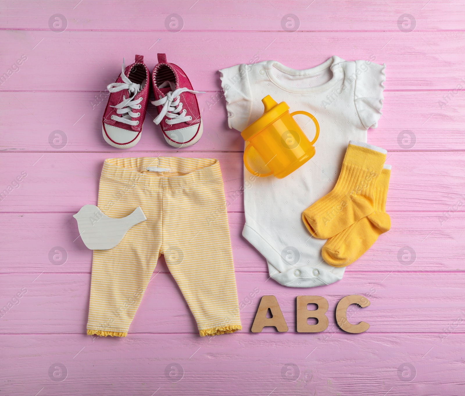 Photo of Flat lay composition with cute clothes on wooden background. Baby accessories