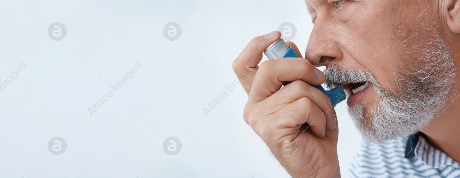 Image of Closeup view of man using asthma inhaler on white background, space for text. Banner design