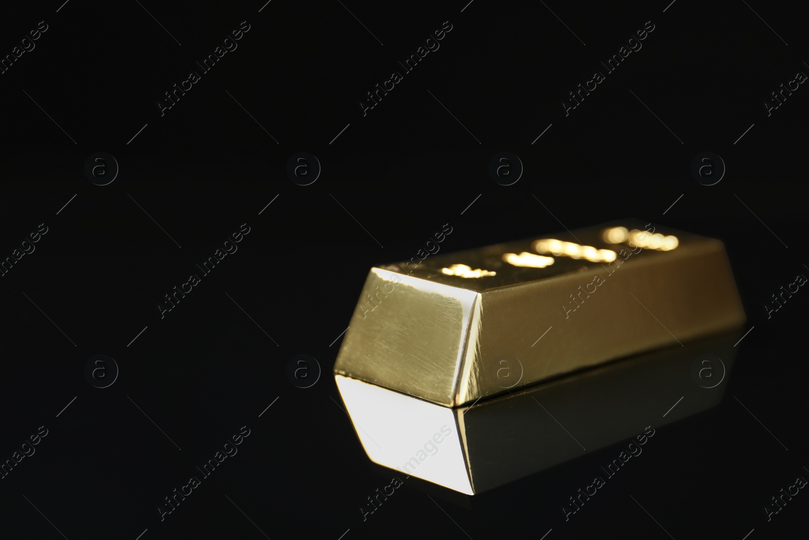 Photo of Shiny gold bar on black background. Space for text