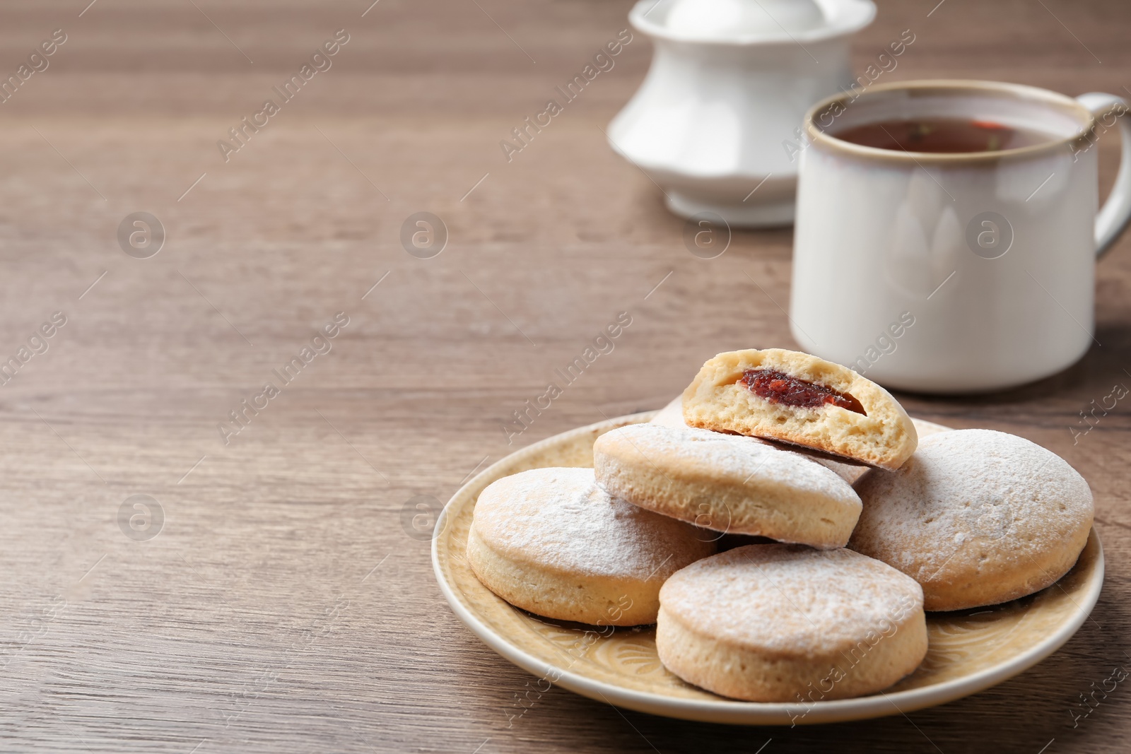 Photo of Traditional Islamic cookies and tea on wooden table, space for text. Eid Mubarak