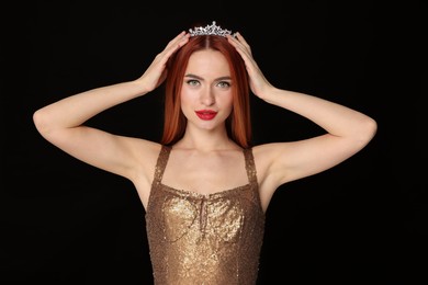Photo of Beautiful young woman with tiara in dress on black background